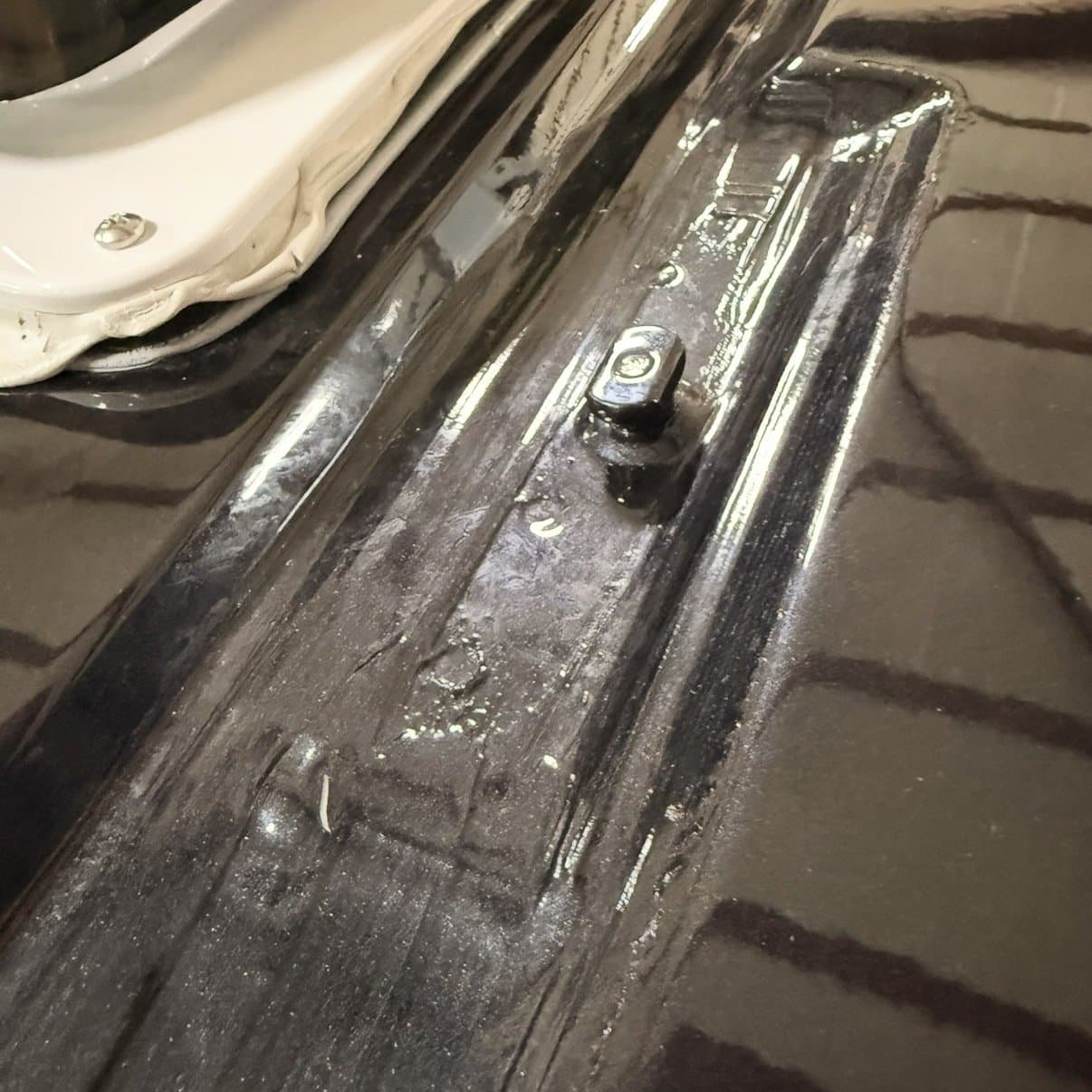 The factory anchor point, already on the van. This is where the rail fixes.